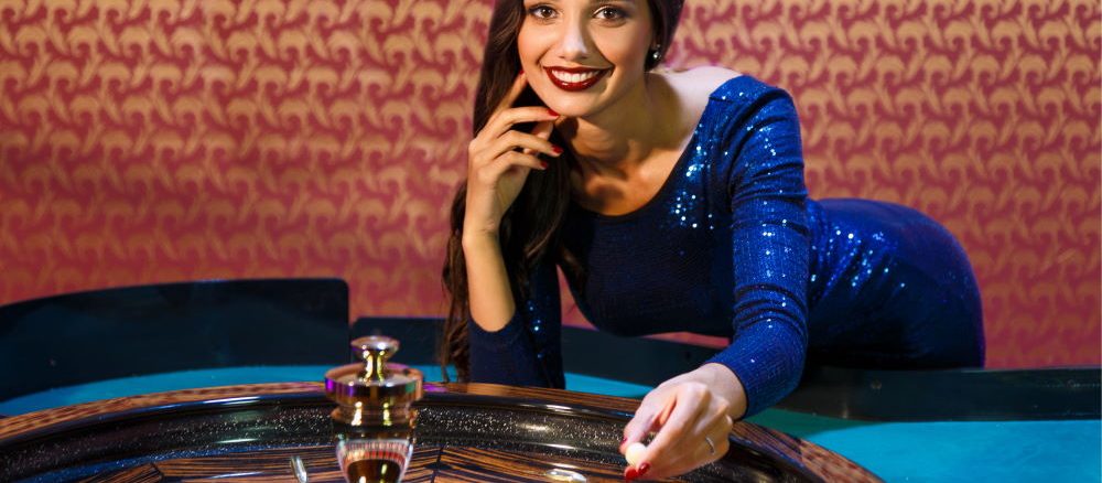 Distribuidor de ruleta femenina detrás de la mesa de ruleta