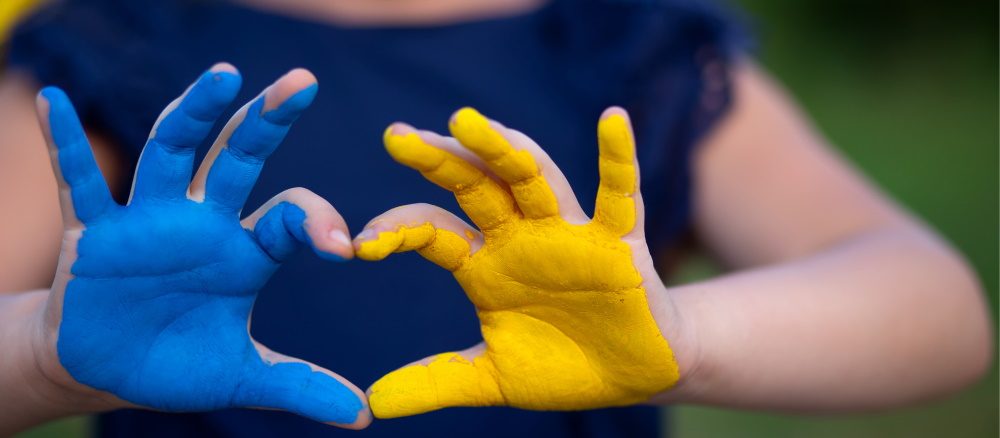 manos en forma de corazón pintadas en el color de la bandera de Ucrania