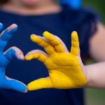 manos en forma de corazón pintadas en el color de la bandera de Ucrania