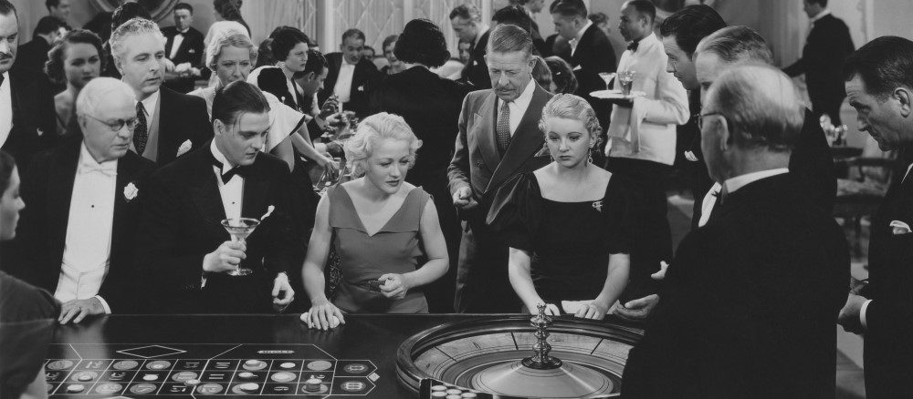 una película en blanco y negro con gente jugando a la ruleta