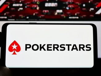 Persona que sostiene un teléfono inteligente con el logotipo de la sala de póquer en línea PokerStars
