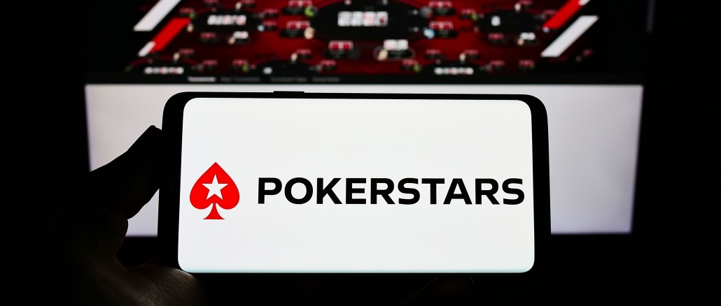 Persona que sostiene un teléfono inteligente con el logotipo de la sala de póquer en línea PokerStars
